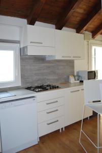 een keuken met witte kasten en een fornuis met oven bij Casa Fiorella in Caorle