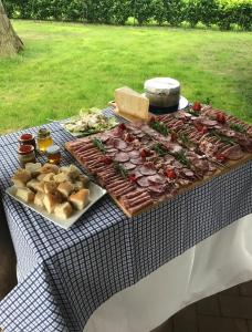 una mesa de picnic con carnes y otros alimentos. en Cascina cattabreghetta, en Pombia