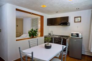 uma cozinha com uma mesa branca e uma cozinha com uma cama em Suite 4A, Terraza, Garden House, Welcome to San Angel em Cidade do México
