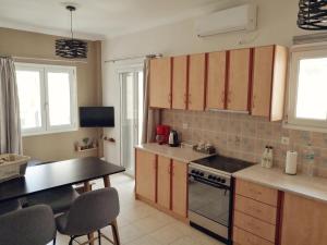 kuchnia z drewnianymi szafkami, stołem i krzesłami w obiekcie Ionian Citizen Apartment w Korfu +16 zdjęć