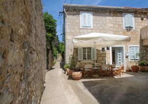 une maison avec un parasol, des tables et des chaises dans l'établissement Holiday Home ART - Bol, à Bol