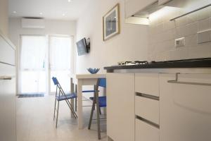 a kitchen with a counter and a table with chairs at L'ONDA 2 - Portovener-Fezzano in Fezzano
