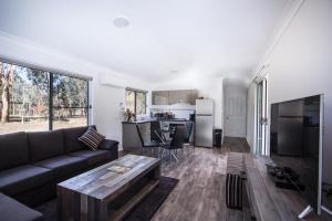 a living room with a couch and a table at Rosewood Cottage in Grattai