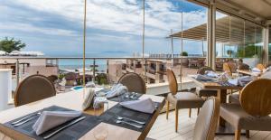 a restaurant with tables and chairs on a balcony at Olympion Sunset Halkidiki in Fourka