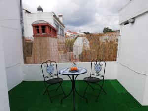 a patio with two chairs and a table with oranges on it at Arronches Villa in Arronches
