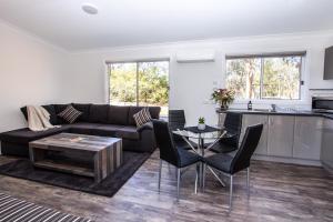 a living room with a couch and a table at Rosewood Cottage in Grattai