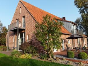 een stenen huis met een balkon en een parasol bij Ferienwohnung Aufderhaar in Ostbevern