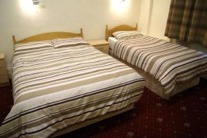 dwa łóżka siedzące obok siebie w pokoju w obiekcie Stanley House Hotel w Londynie
