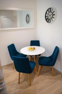 a table with four chairs and a plate of fruit on it at Srecko Exclusive Apartment in Belgrade