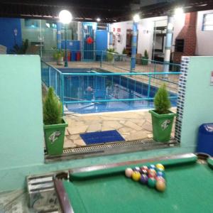 a pool table with balls on it next to a swimming pool at Pousada Recanto Dom Lázaro in Cesário Lange