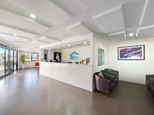 un vestíbulo de oficina con recepción y sillas en Value Suites Penrith, en Penrith