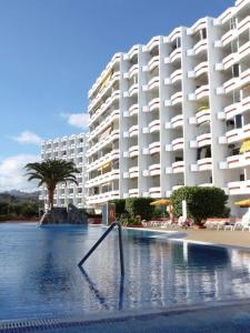 un grande edificio bianco accanto a una piscina di Agaete parque Playa del Inglés a Playa del Ingles
