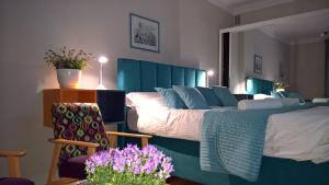 1 dormitorio con 1 cama grande con sábanas azules y flores púrpuras en Comfort In Warsaw Apartment, en Varsovia