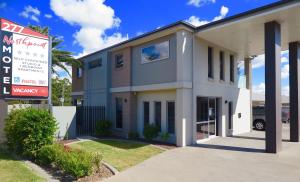 uma casa com um sinal em frente em Northpoint Motel Apartments em Toowoomba