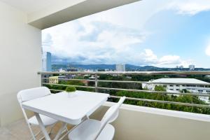 einen weißen Tisch und Stühle auf einem Balkon mit Aussicht in der Unterkunft St Mark Hotel in Cebu City