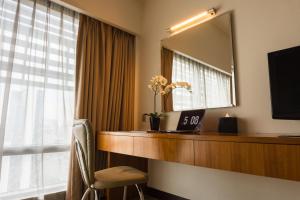 a hotel room with a desk and a mirror at Premiera Hotel Kuala Lumpur in Kuala Lumpur