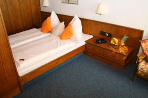 Schlafzimmer mit einem großen Bett mit einem Kopfteil aus Holz in der Unterkunft Landhotel Sonnenbühl in Sonnenbühl