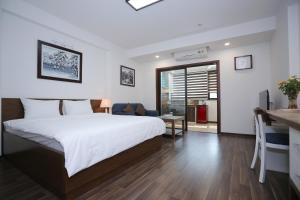 Pokój hotelowy z łóżkiem, biurkiem i kuchnią w obiekcie Cat Linh ARL55 Hotel w mieście Hanoi