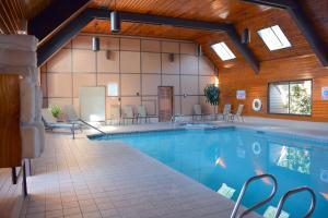 a large swimming pool with chairs and tables in a building at SureStay Plus Hotel by Best Western Gold Beach in Gold Beach