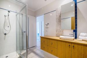 a bathroom with a shower, sink, and tub at Sunseeker Holiday Apartments in Sunshine Beach