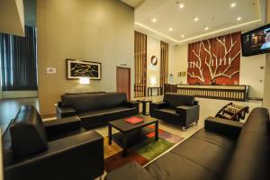 a living room with couches and a tv in it at Garden Sentral Hotel in Kuala Belait