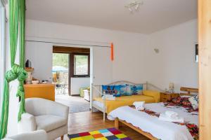 a bedroom with a bed and a couch and a chair at Poseydon Beach Bungalow in Mlini