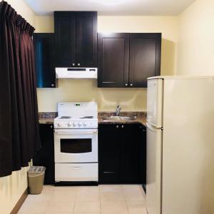 a kitchen with a white stove and a refrigerator at Kings Motor Inn in Kamloops