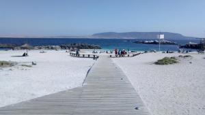 una pasarela de madera en una playa con gente en ella en Casa Bahia Inglesa, en Bahía Inglesa