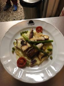 un piatto di alimenti con carne e verdure su un tavolo di Locanda Al Cappello a Udine