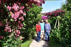 a group of three people standing in front of flowers at Lemon Garden Lodge in Cıralı