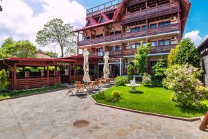 a hotel with a courtyard with tables and chairs at Casa Luca in Vama Veche