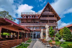 a large wooden building with chairs in front of it at Casa Luca in Vama Veche