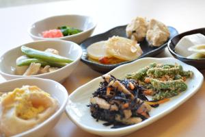 a table with plates of food and bowls of food at Kanazawa Sainoniwa Hotel in Kanazawa