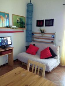 ein Wohnzimmer mit einem Sofa und roten Kissen in der Unterkunft C'era Una Volta in Ripatransone