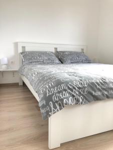 ein weißes Bett mit einer schwarzen und weißen Bettdecke und Kissen in der Unterkunft Holiday House Tesser with Pool in Galižana