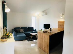 ein Wohnzimmer mit einer blauen Couch und einem Fernseher in der Unterkunft Holiday House Tesser with Pool in Galižana