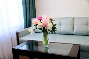 a vase of pink and white flowers sitting on a table at Hotel Tourist in Rivne