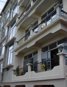 a white building with balconies and windows at Golden Dolma in Darjeeling