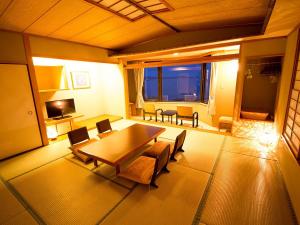 Naruto Grand Hotel Kaigetsu في ناروتو: غرفة معيشة مع طاولة وكراسي خشبية