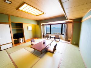 a room with a table and chairs and a view of the ocean at Naruto Grand Hotel Kaigetsu in Naruto +7 photos