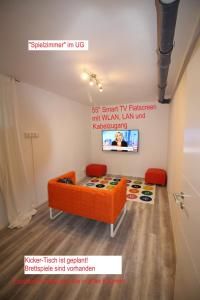 ブリクセン・イム・ターレにあるChoralm-Blickのオレンジ色のソファと赤い椅子2脚が備わる客室です。