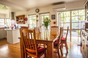 a kitchen and dining room with a wooden table and chairs at The Loft Bed and Breakfast in Taupo