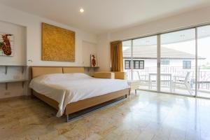 Un dormitorio con una cama grande y grandes ventanales. en Galare Thong Tower, en Chiang Mai