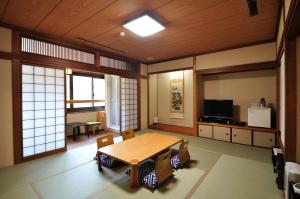 Habitación grande con mesa de madera y sillas. en Obokekyo Mannaka en Miyoshi