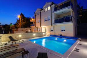 a swimming pool in front of a house at night at Villa Karamba in Senj