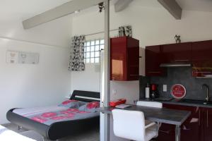 a room with a bed and a table and a kitchen at Villa Azurella in Brignoles