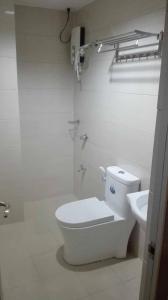 a white bathroom with a toilet and a sink at Meaco Royal Hotel - Tabaco in Tabaco
