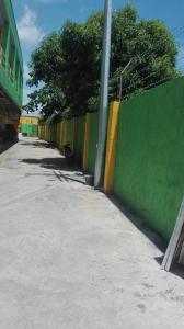 a green and yellow wall next to a street at Meaco Royal Hotel - Tabaco in Tabaco