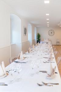 un lungo tavolo con bicchieri da vino e tovaglioli di Hôtel-de-Ville d'Attalens a Attalens