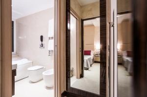 bagno con servizi igienici, lavandino e specchio di Maison Candia Luxury House a Roma